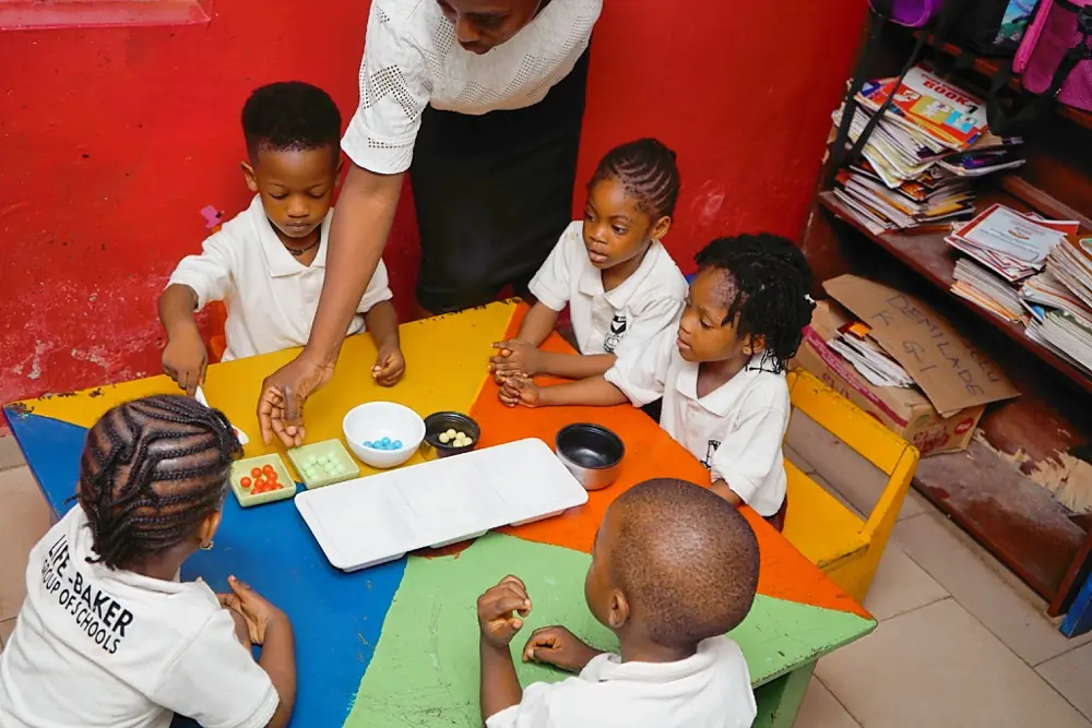 Nursery staff helping toddlers at snack time