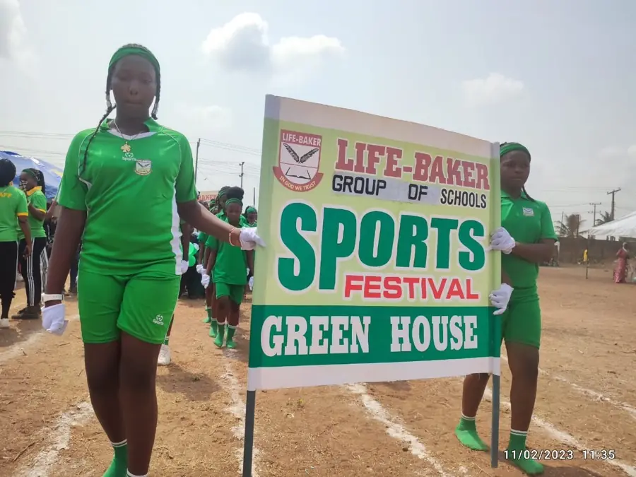 A student carrying the Green House banner