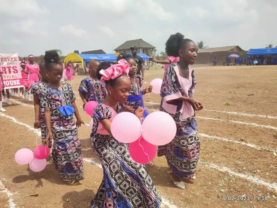 Pupils in traditional dress carrying balloons