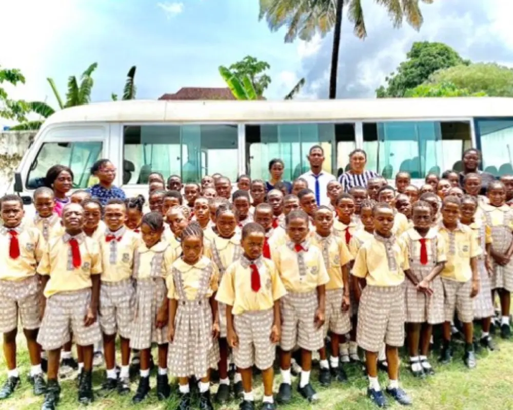 Primary pupils in uniform gathered in front of the school coach before an excursion